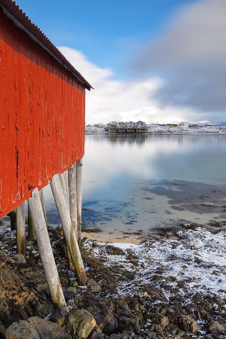 eine klassische Rorbuer entlang der Küste der Insel Hillesoya an einem bewölkten Wintertag, Hillesoya, Troms, Norwegen, Europa