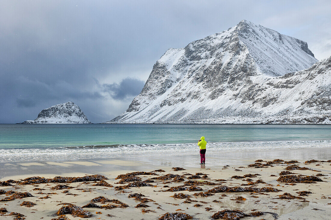 eine Person genießt die schöne Aussicht am Haukland Strand an einem Wintertag, Vestvagoy, Lofoten, Norwegen, Europa