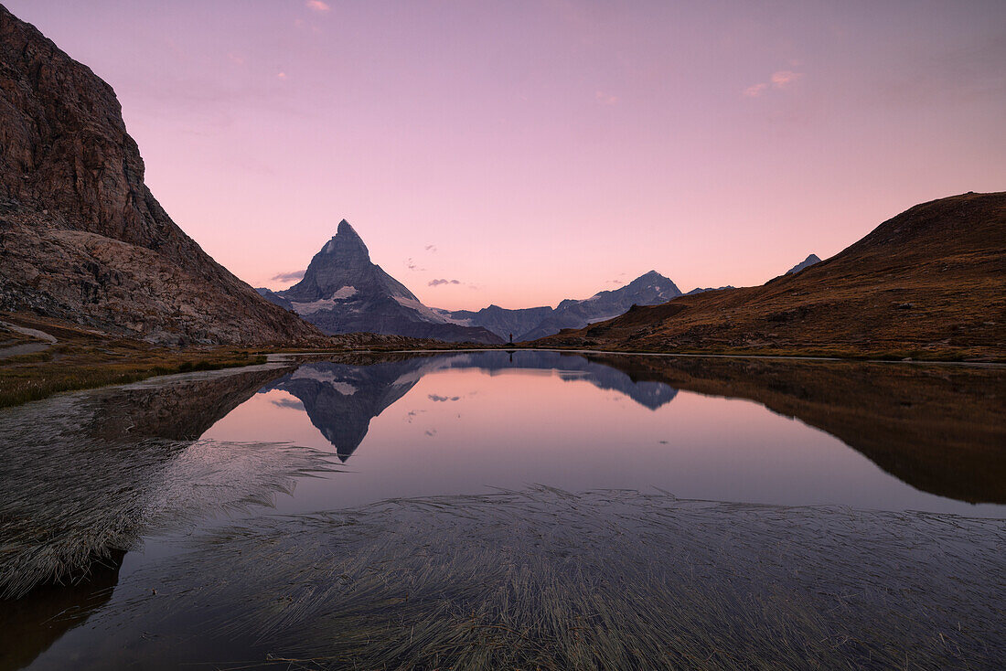 the Riffelsee lake during a summer morning, with the iconic Matterhorn in background, Zermatt, Canton of Valais, Switzerland, Europe