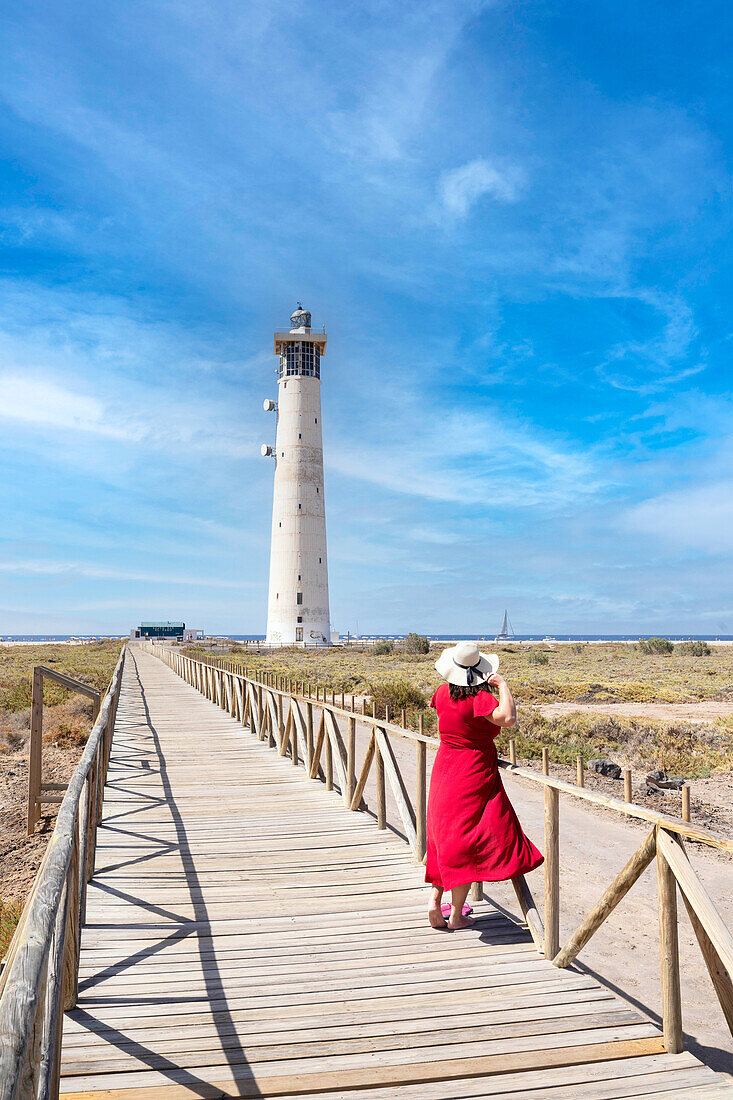 a tourist admires the view near the Morro Jable lighthouse during a sunny summer day, Fuerteventura, Canary Island, Spain, Europe