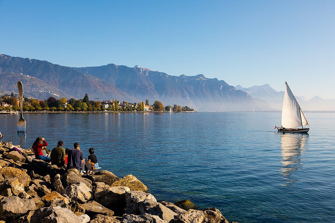 Boat sailing on lake geneva with the strollers and the fork of vevey in the background, sculpture by the swiss artist jean-pierre zaugg for the 10th anniversary of alimentarium, the fork, nestle museum, offbeat, lake geneva, vevey, canton of vaud, switzerland