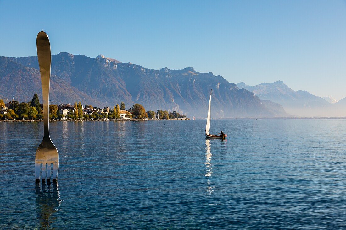 Boat sailing near the fork of vevey in lake geneva, sculpture by the swiss artist jean-pierre zaugg for the 10th anniversary of alimentarium, the fork, nestle museum, offbeat, lake geneva,vevey, canton of vaud, switzerland