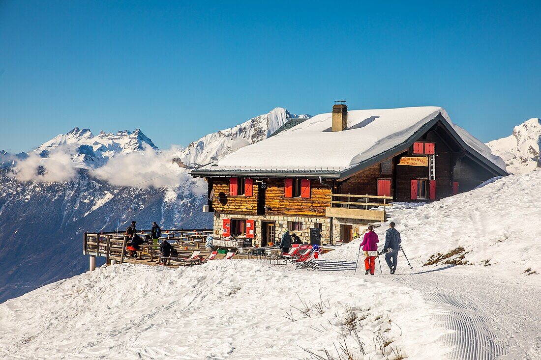 Touristen wandern in Richtung eines Bergrestaurants auf den Höhen von Haute-Nendaz, Chalet, Tourismus, Schweizer Alpen, Kanton Wallis, Schweiz