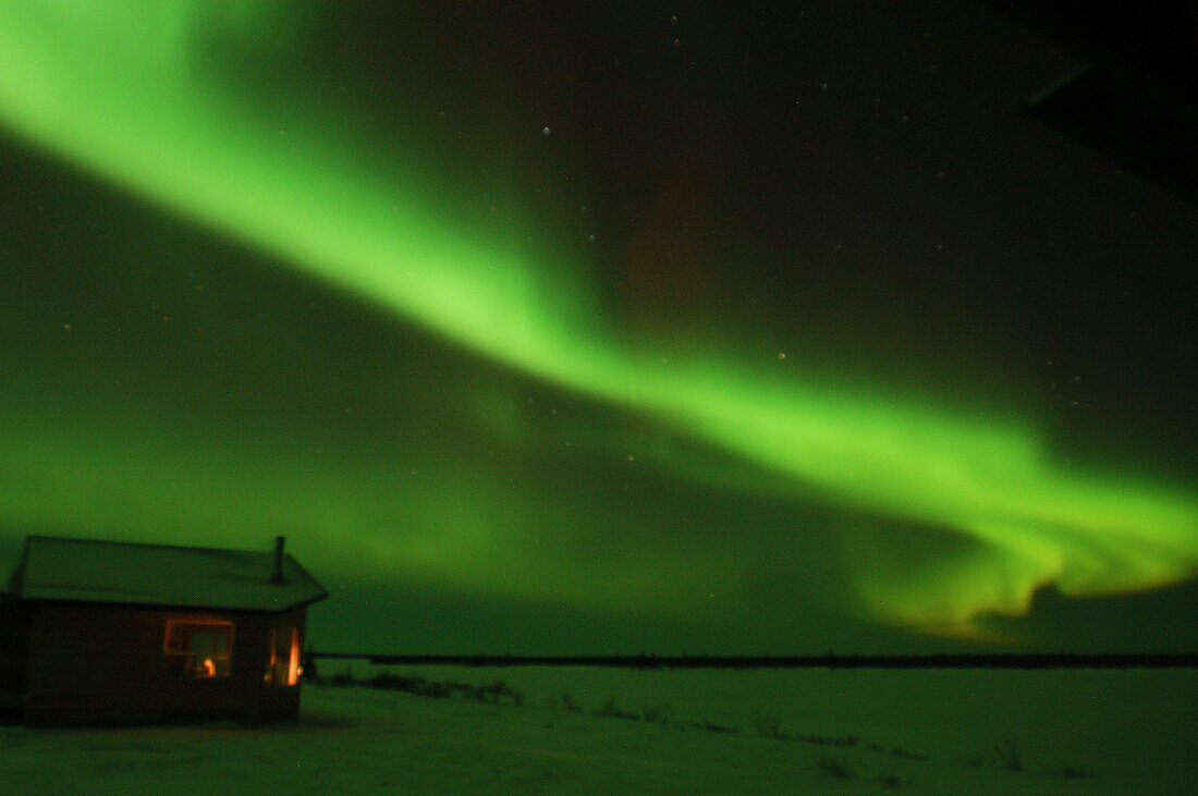 Aurora Borealis Northern Lights over tundra lodge at Dymond Lake near Churchill, Manitoba, sub-arctic, Northern Canada