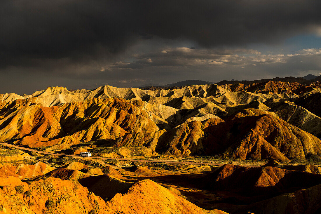 Touristenbus bei Sonnenuntergang in den Regenbogenbergen des geologischen Nationalparks Zhangye Danxia