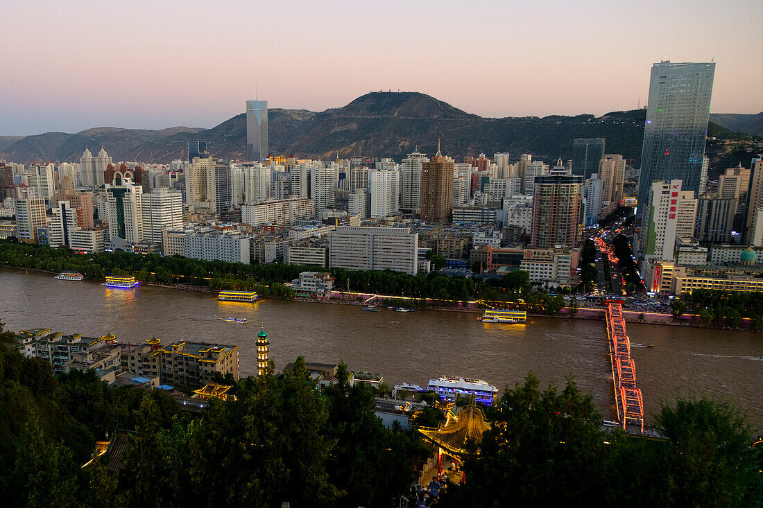 The Yellow River or Huang He in Lanzhou with the city skyline at sunset