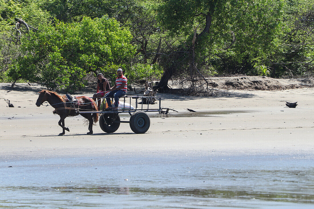 Pärchen auf einem Pferdewagen am Strand, Jiquilillo, Nicaragua