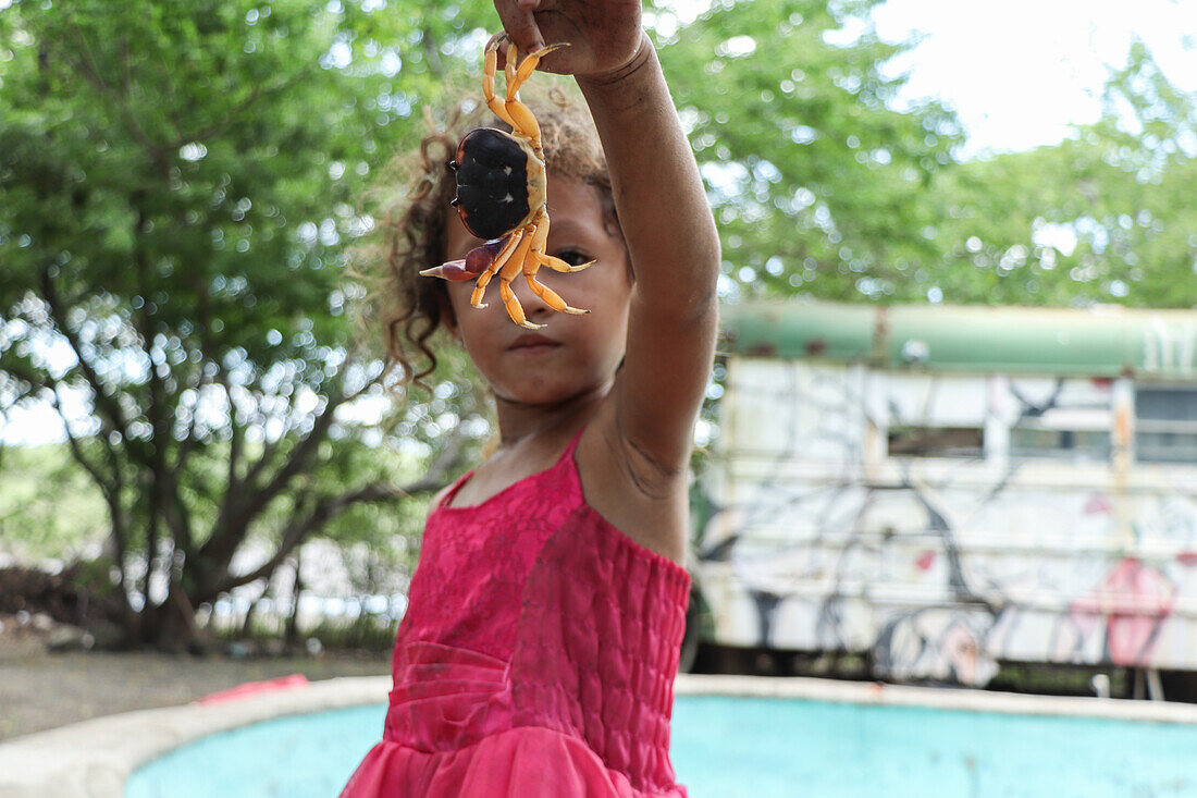 Britany, a 4 year old girl from Jiquilillo, playing with a crab, Nicaragua