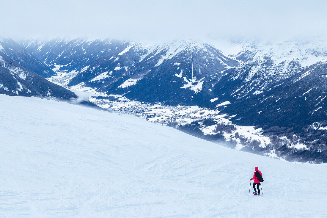 A mountaineer snowshoeing on the snow capped Patscherkofel mountain, with the Stubai Valley in the background, Tux alps, Innsbruck Land, Tyrol, Austria, Europe