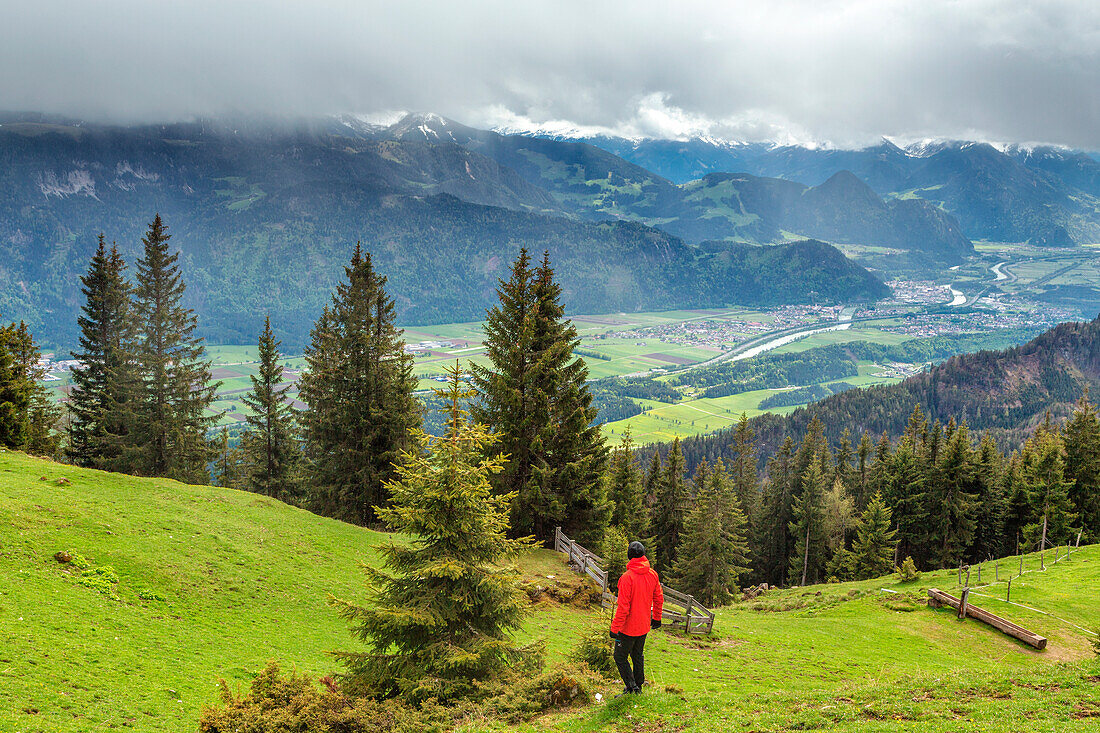 Ein Wanderer steht auf den Wiesen der Jocheralm und blickt auf das Inntal, Region Brandenberg, Bezirk Kufstein, Tirol, Österreich, Europa