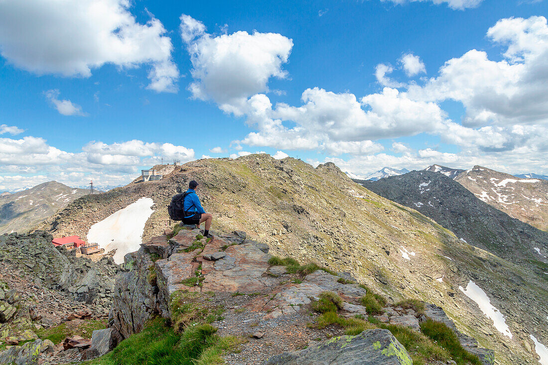 A mountaineer on the summit of Sonnenspitze mountain with the Glungezer Peak and the Tux mountains in the background, Tulfes, Innsbruck Land, Tyrol, Austria, Europe