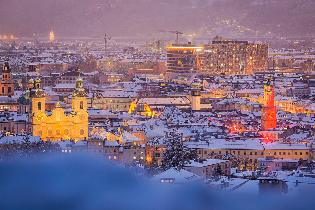 Das Stadtzentrum mit seinen ikonischen Gebäuden vom Stadtteil Hötting aus gesehen an einem verschneiten Abend, Innsbruck, Tirol, Österreich, Europa