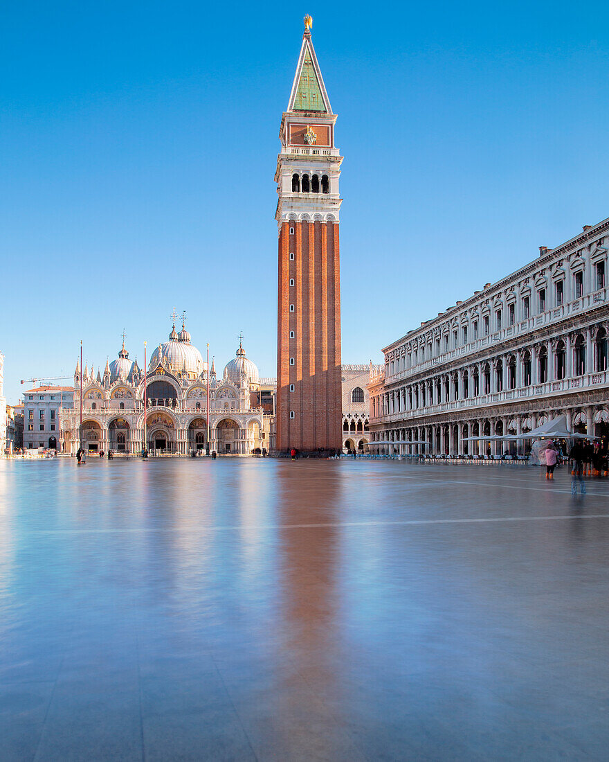 Blick auf das Acqua Alta auf dem Markusplatz mit seinen ikonischen Gebäuden, der Basilika und dem Glockenturm, an einem sonnigen Morgen, Venedig, Provinz Venedig, Region Venetien, Italien, Europa