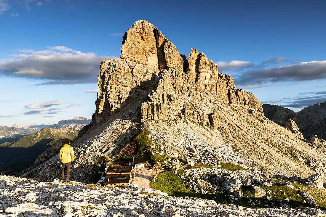 Italien, Venetien, Provinz Belluno, ein Wanderer bewundert die Sonne, die die Felsen des Monte Averau und die gemütliche Hütte beleuchtet (MR)