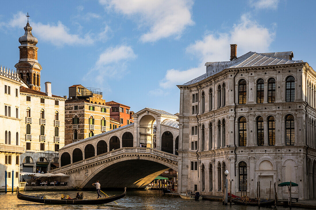 Italy,Veneto,Venice,a typical gondola sails on the Canal Grande (Grand Canal), with Ponte di Rialto (Rialto Bridge) in the background