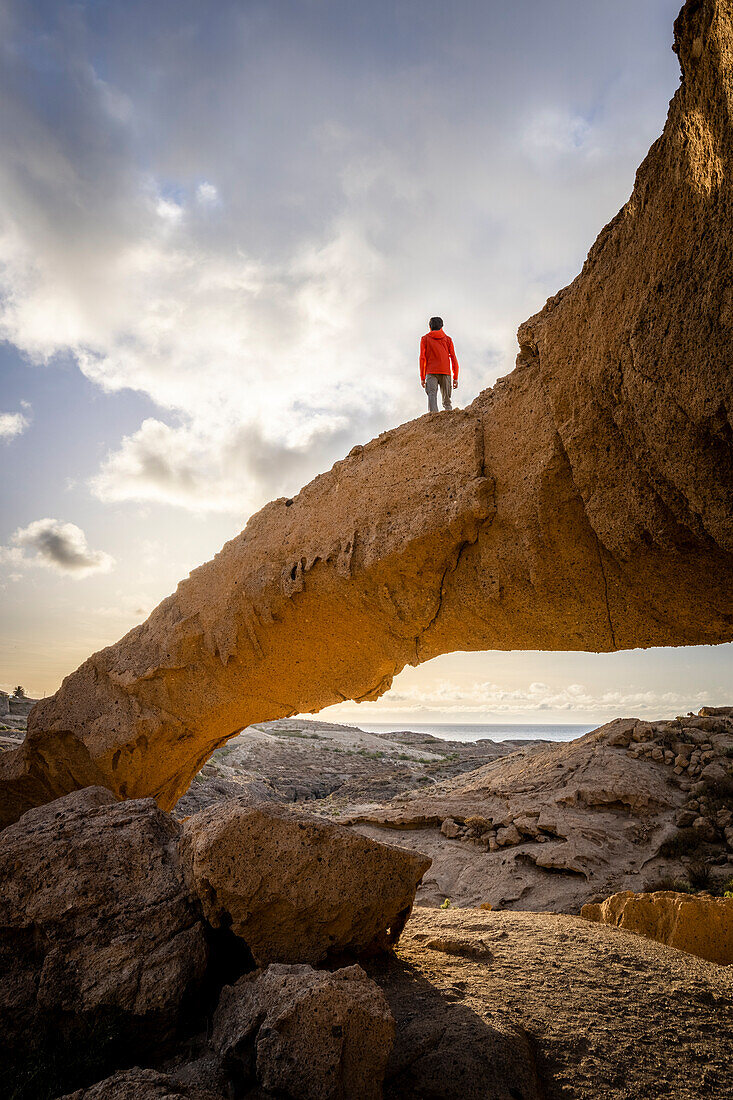 Spanien,Kanarische Inseln,Teneriffa,Santa Cruz de Tenerife, ein Mann steht auf der natürlichen Formation des vulkanischen Tuffsteins des Arco de Tajao (MR)