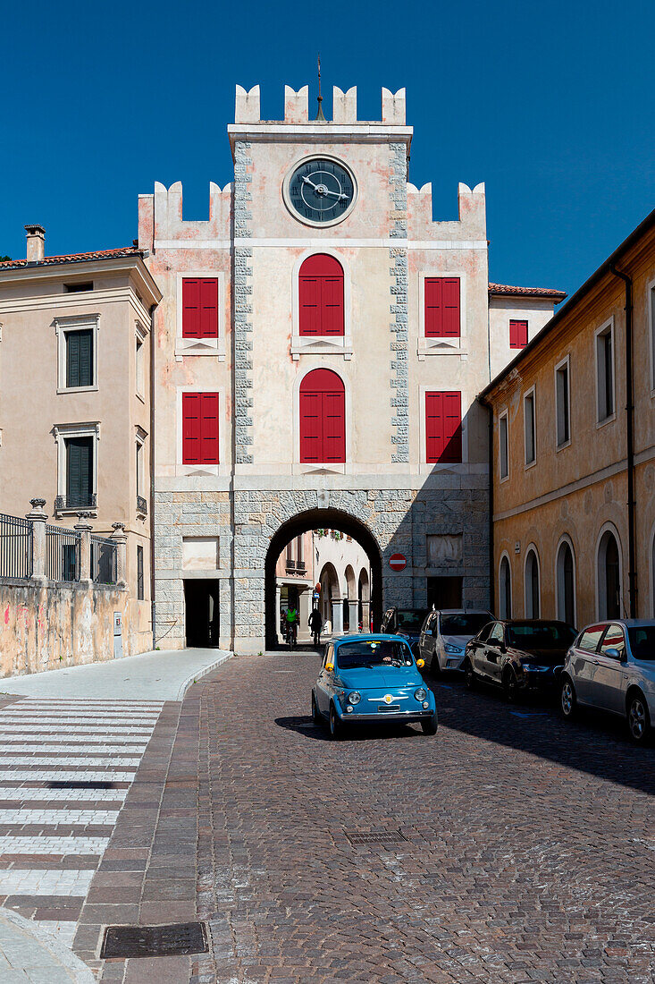 A Fiat 500 leaves the city center of Vittorio Veneto. Europe, Italy, Veneto, Province of Treviso, Vittorio Veneto