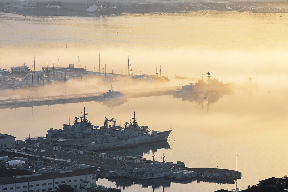 Maritimer Nebel in der Morgendämmerung über Porto Mirabello und einem Teil des Militärarsenals von La Spezia, Provinz La Spezia, Region Ligurien, Italien, Europa.