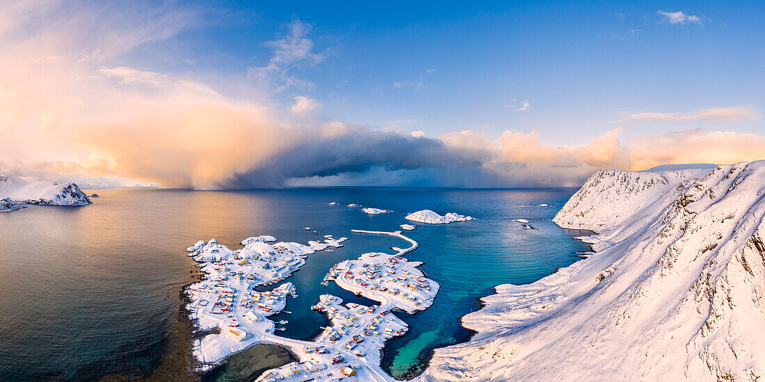 Das Küstendorf Sorvaer ist während des Sonnenaufgangs im kalten arktischen Winter mit Schnee bedeckt (Insel Soroya, Hasvik, Troms og Finnmark, Norwegen)