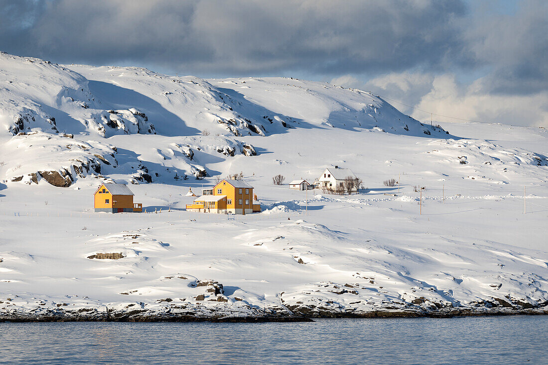 Hasvik Village: schneebedeckte Häuser während des kalten arktischen Winters (Soroya Island, Troms og Finnmark, Norwegen)