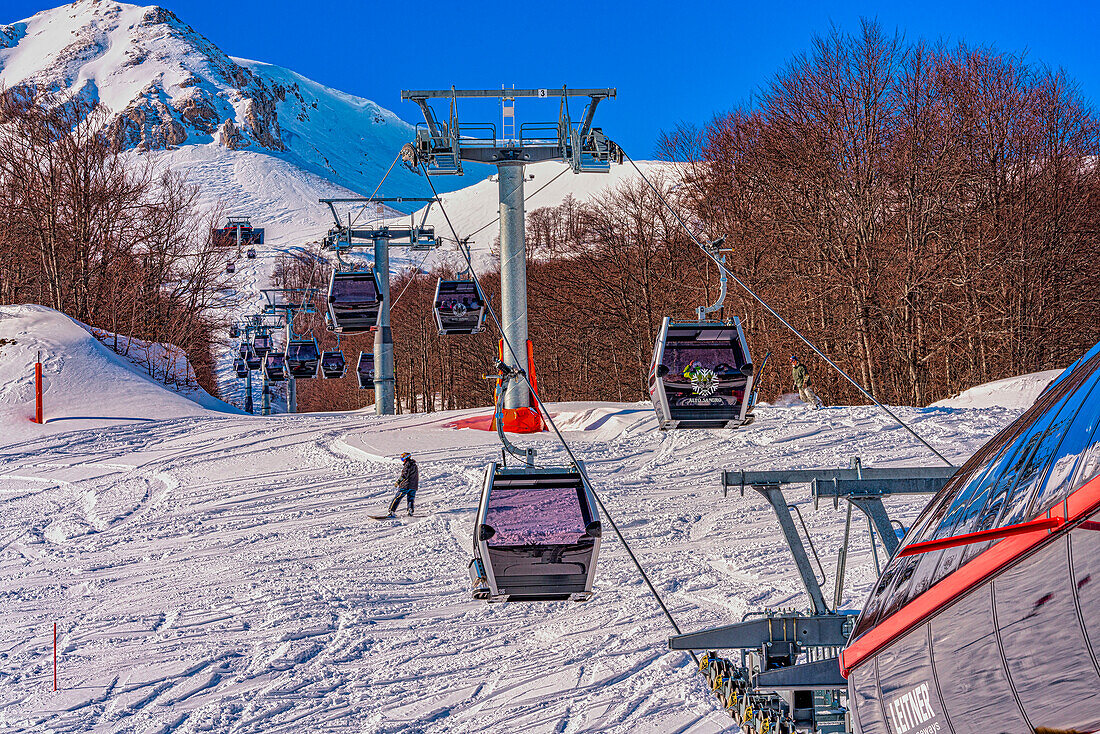 Panoramakabinen bringen die Skifahrer auf die Pisten. Seilbahn Pallottieri. Aremogna skyresort, Roccaraso, Provinz L'Aquila, Abruzzen, Italien
