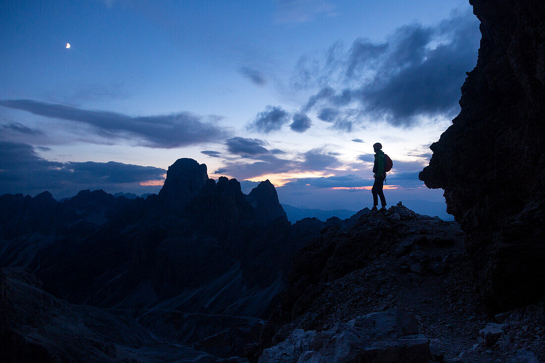 Hiker silhouette along the iron path to Catinaccio di Antermoia mount from Principe refuge atu sunset. Pozza di Fassa, Fassa Valley, Trentino, Italy.