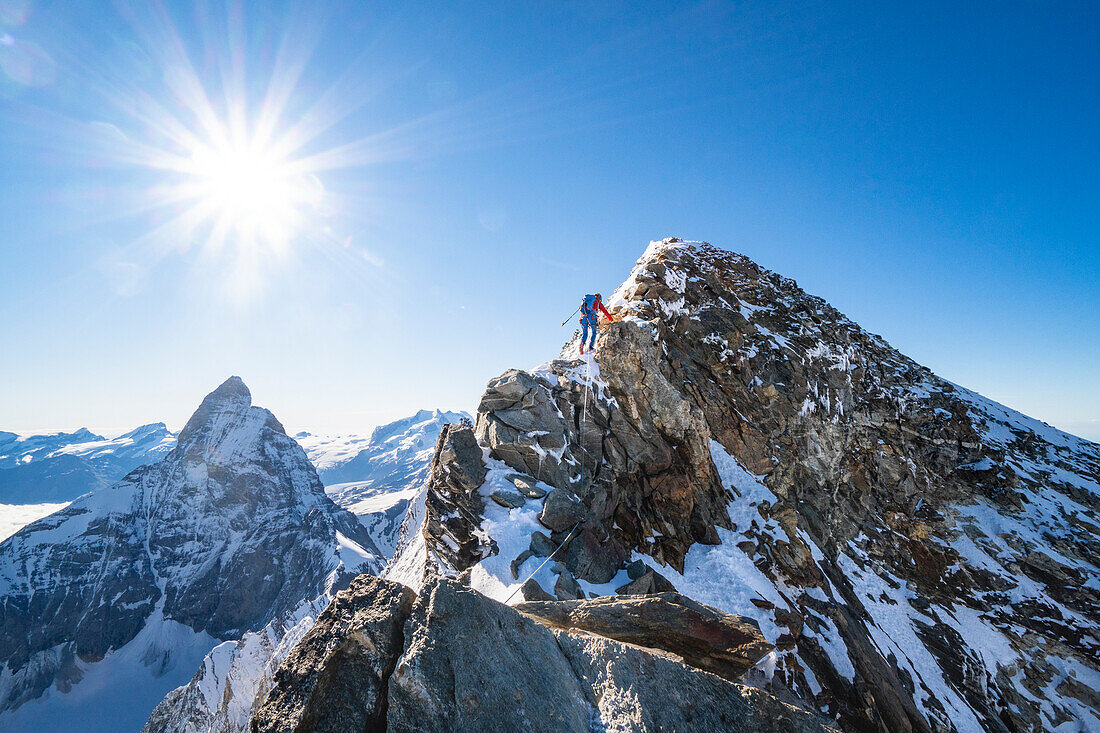 Alpinist auf dem letzten Grat zum Gipfel des Dent d Herens. Mit der Nordwand des Matterhorns im Hintergrund. Valpelline-Tal, Bionaz, Aosta-Tal, Alpen, Italien, Europa.