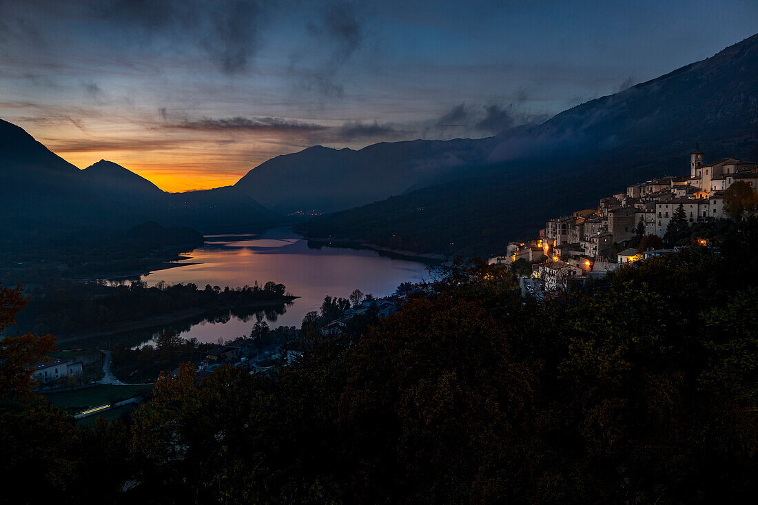 Sonnenuntergang am Barrea-See, das Dorf Barrea bewacht den See. Abruzzen-Nationalpark, Latium und Molise, Abruzzen, Italien, Europa