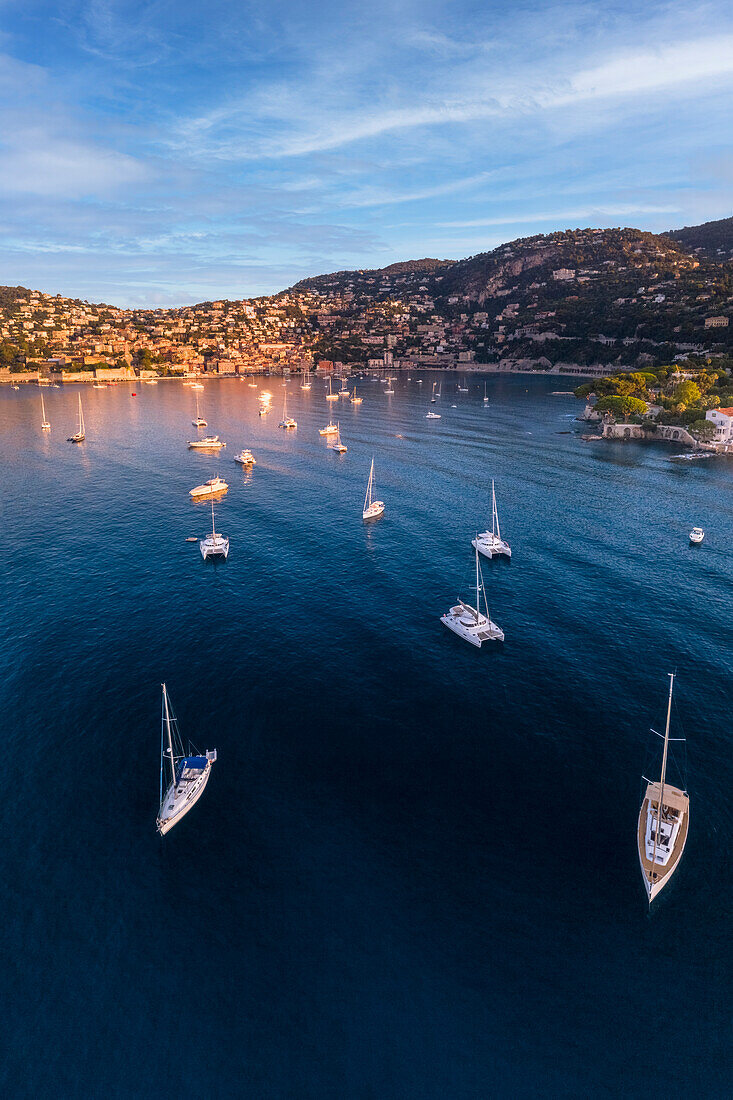 Sailing boats moored in the bay in front of Villefranche village at sunrise (Villefranche-sur-Mer, Beausoleil canton, Nice, Alpes-Maritimes department, Provence-Alpes-Cote d'Azur region, France, Europe)
