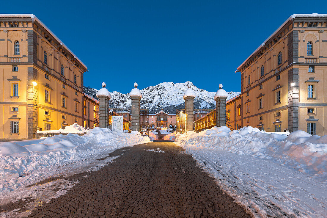The entrance gate of the Marian Sanctuary of Oropa after an heavy snowfall at morning twilight (Biella, Biella province, Piedmont, Italy, Europe)