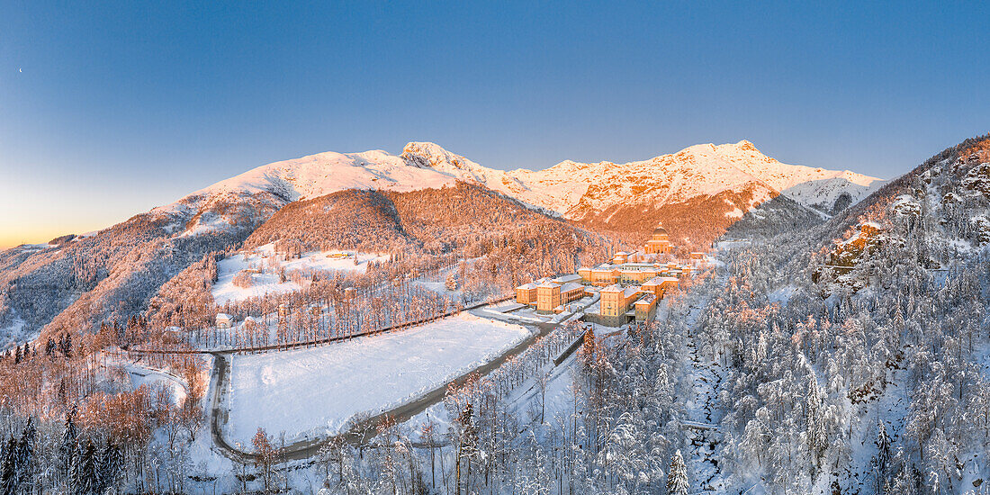 Panoramablick auf das Oropa-Tal: das Marienheiligtum von Oropa nach starkem Schneefall bei Sonnenaufgang (Biella, Provinz Biella, Piemont, Italien, Europa)