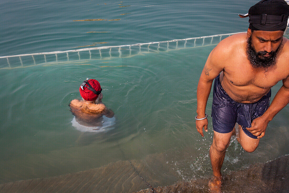 pilgrims bathing in the sacred pool Amrit Sarovar, Golden temple, Amritsar, Punjab, India