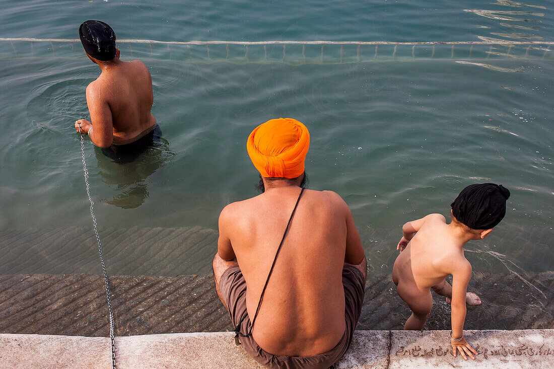 Pilger beim Baden im heiligen Becken Amrit Sarovar, Goldener Tempel, Amritsar, Punjab, Indien