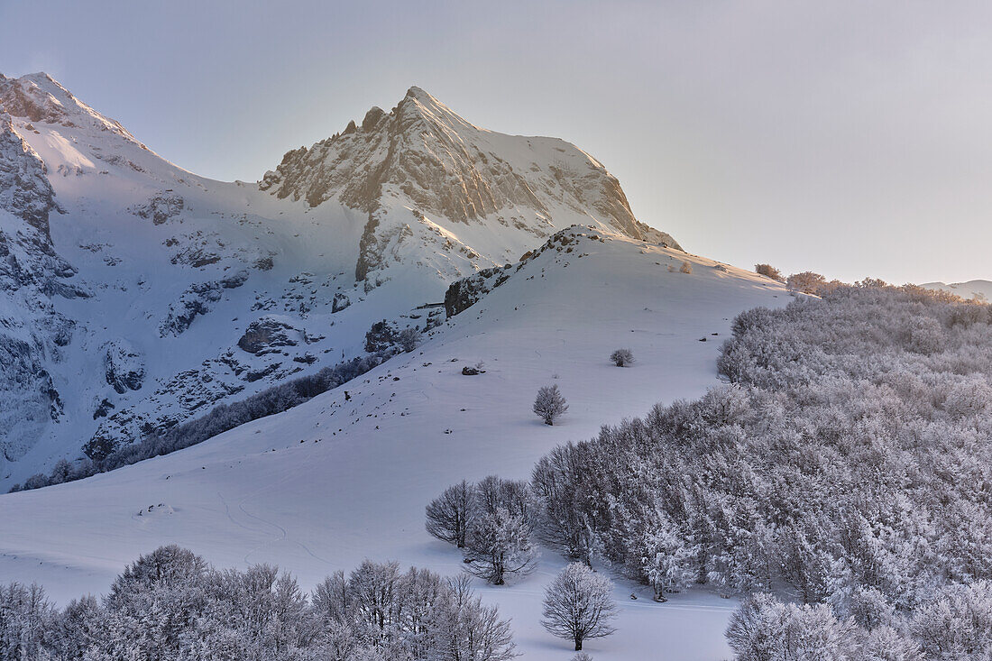 Corno Piccolo Peak at sunset struck by the grazing rays of the sun over a winter landscape. Pietracamela, Teramo district, Abruzzo, Italy