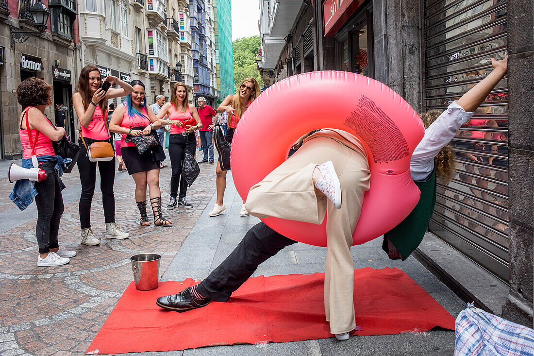 Spontane Frau posiert für ihre Freunde mit einem Straßenkünstler, Altstadt (Casco Viejo), Bilbao, Spanien