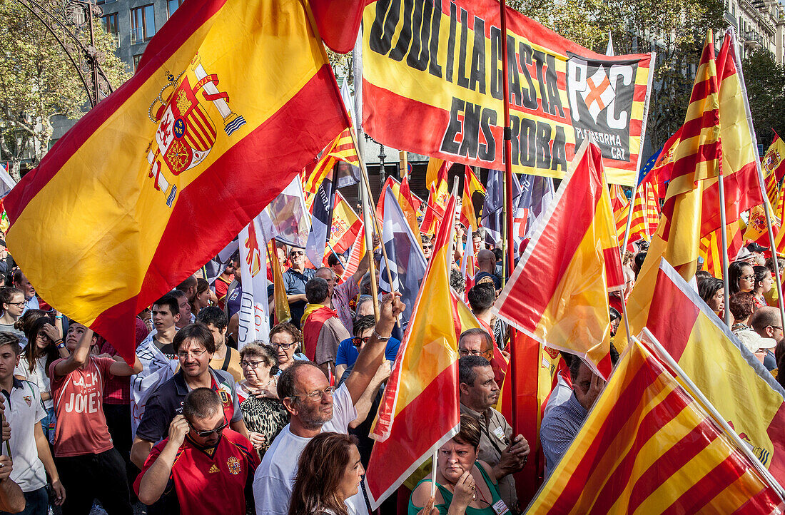 Unabhängigkeitsfeindliche katalanische Demonstranten tragen spanische und katalanische Fahnen während einer Demonstration für die Einheit Spaniens anlässlich des spanischen Nationalfeiertags am 12. Oktober 2014 am Passeig de Gracia in Barcelona, Spanien