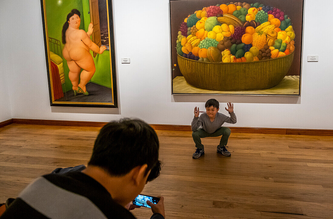Besucher. Rechts `Canasta de frutas'. Links "Frau vor einem Fenster", Botero Museum, Bogota, Kolumbien
