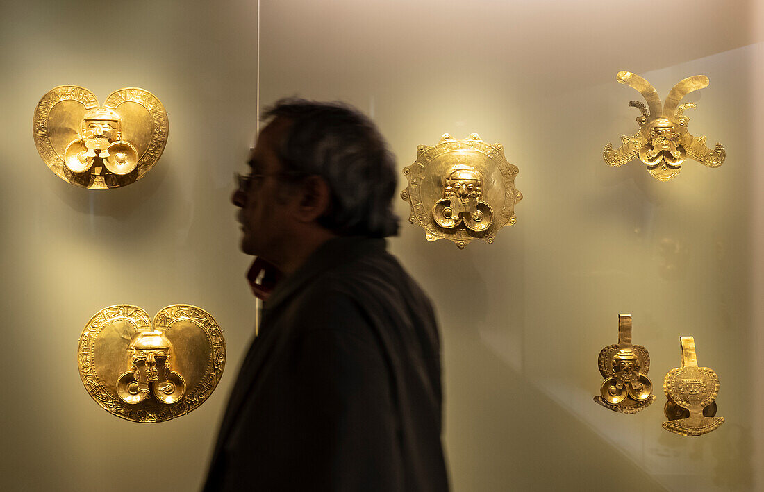 Visitor infront of Pectorals, Pre-Columbian goldwork collection, Gold museum, Museo del Oro, Bogota, Colombia, America