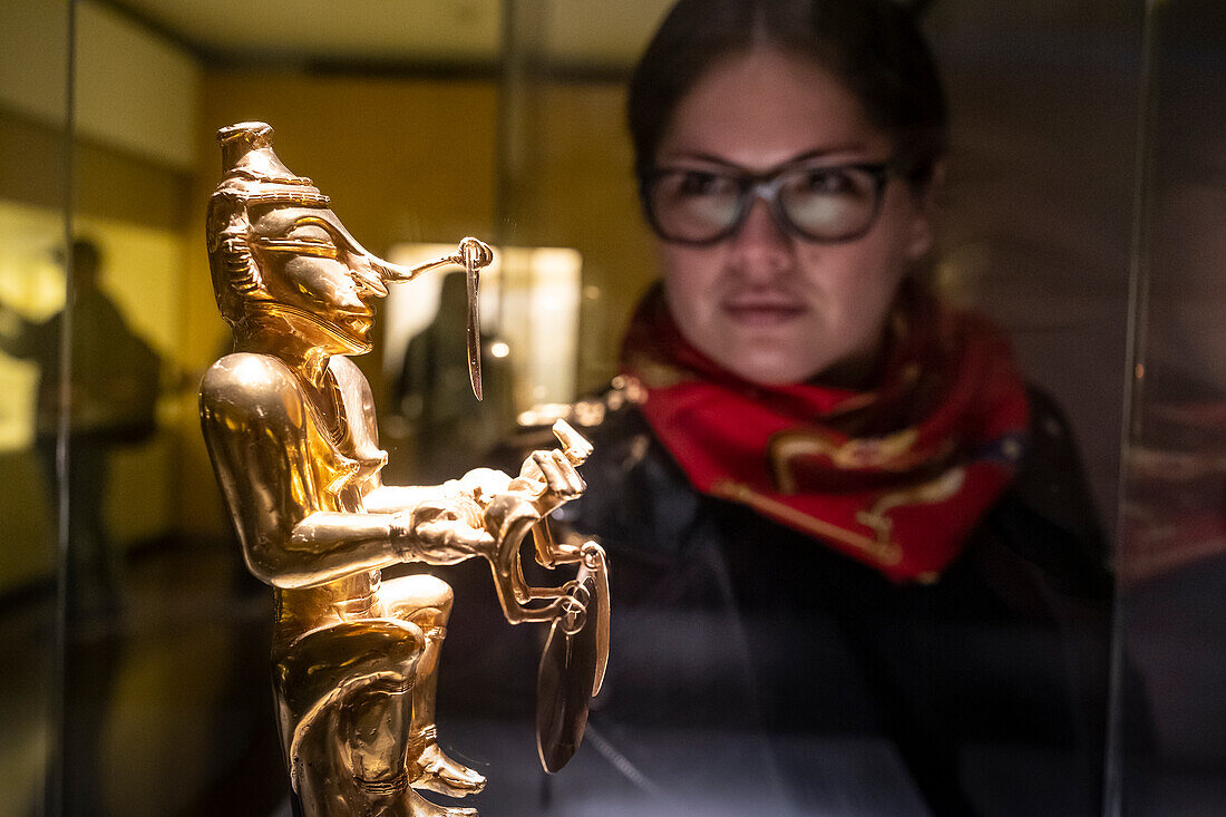 Visitors observing Poporo, anthropomorphous, Pre-Columbian goldwork collection, Gold museum, Museo del Oro, Bogota, Colombia, America