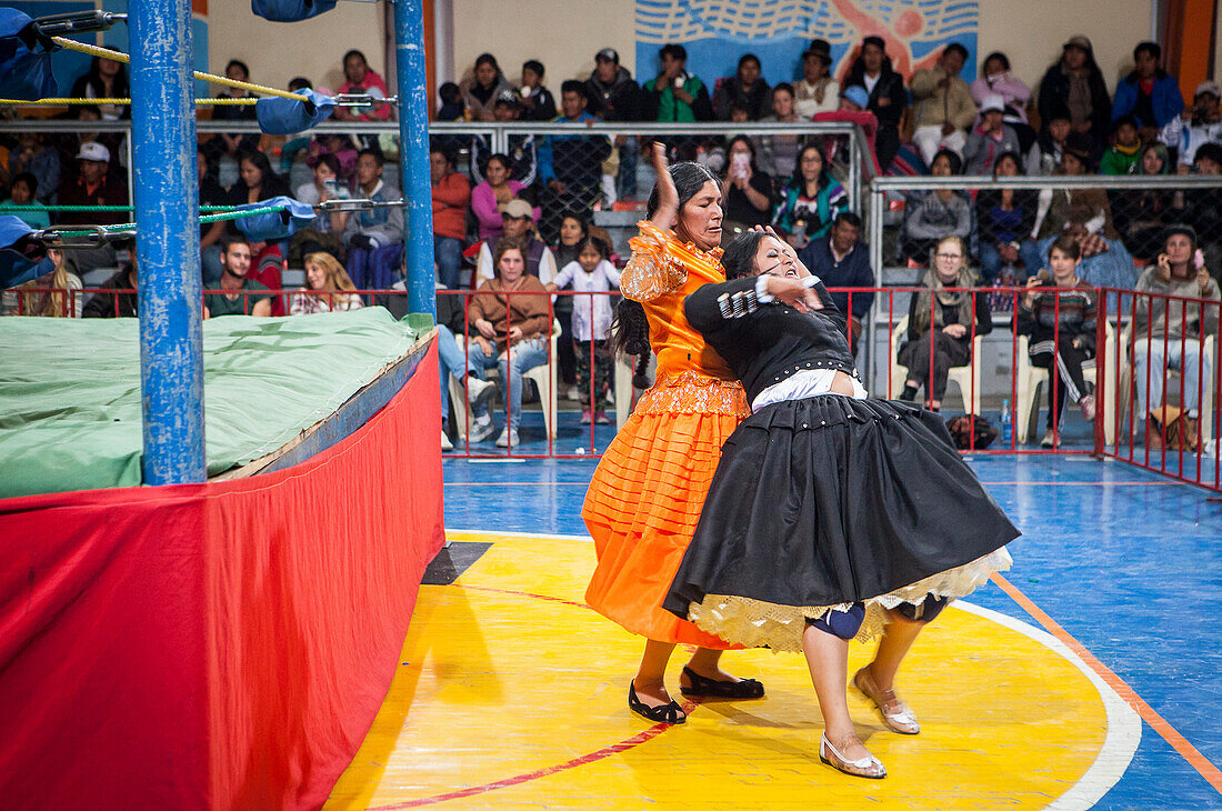 Lucha Libre. Kampf zwischen Dina mit orangefarbenem Kleid und Julieta, Cholitas weibliche Ringerinnen, Sportzentrum La Ceja, El Alto, La Paz, Bolivien