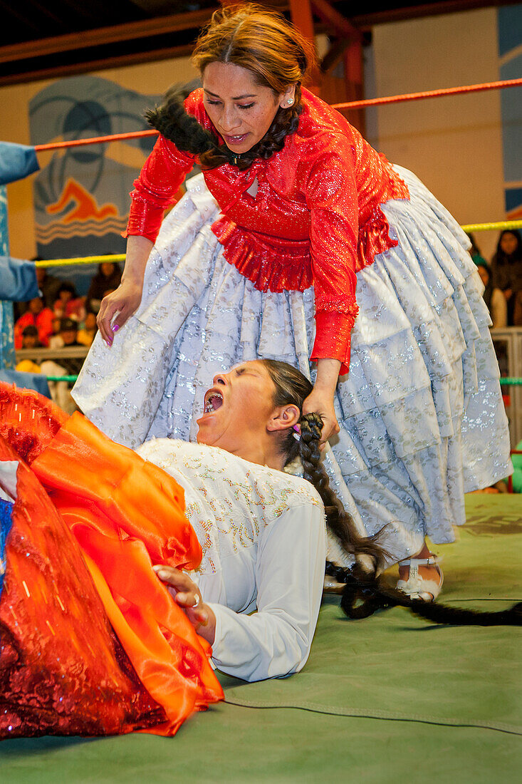 Lucha Libre. Kampf zwischen Dina mit orangenem Rock und Benita la Intocable , cholitas Ringerinnen , Sportzentrum La Ceja, El Alto, La Paz, Bolivien