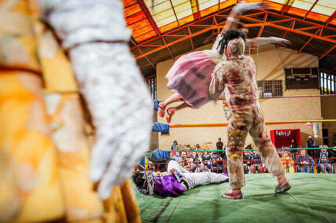 Lucha Libre. Angela la Simpatica, die sich über la Momia häutet, männliche und weibliche cholitas Wrestler im Kampf, Sportzentrum La Ceja, El Alto, La Paz, Bolivien