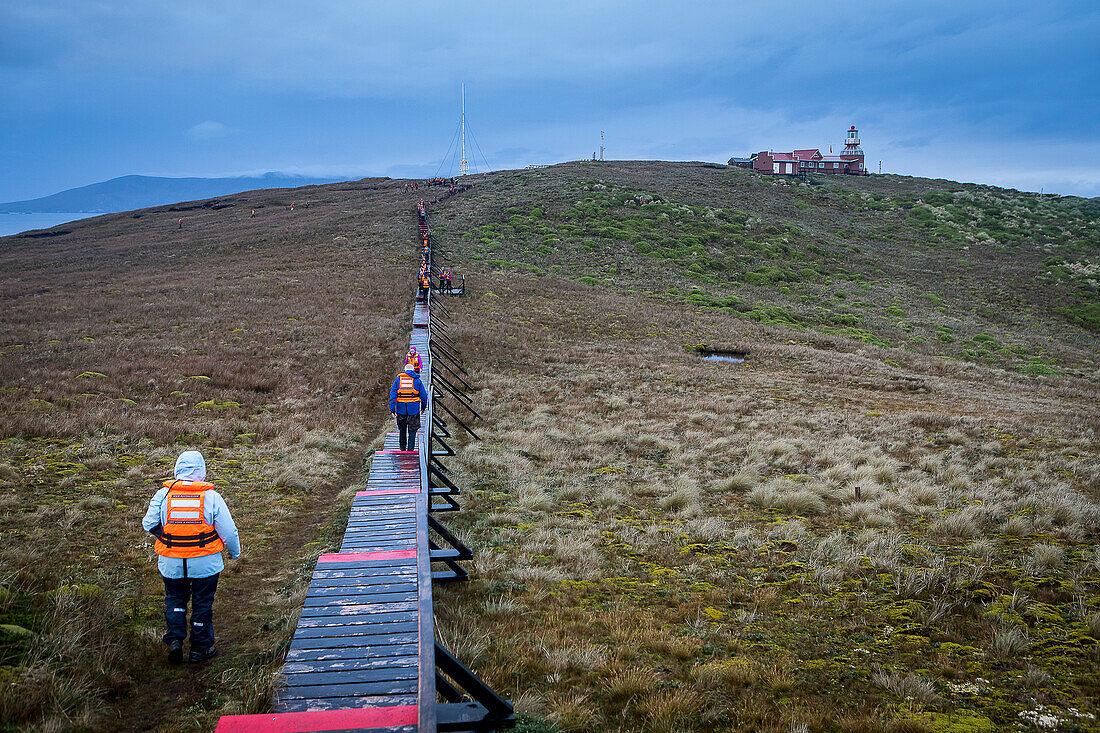 Explorers walking to lighthouse, Cape Horn, Tierra de Fuego, Patagonia, Chile