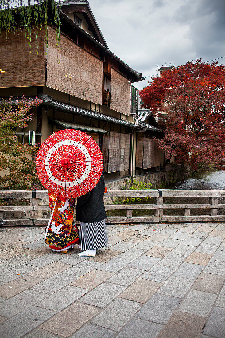 Couple dressed in traditional costume, in Shirakawa-minami-dori, Gion district, Kyoto. Kansai, Japan.