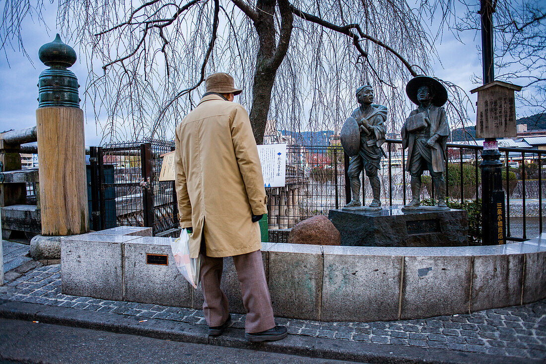 Man watching the Pilgrim Monument in Pontocho, Kamo river,Kyoto, Japan