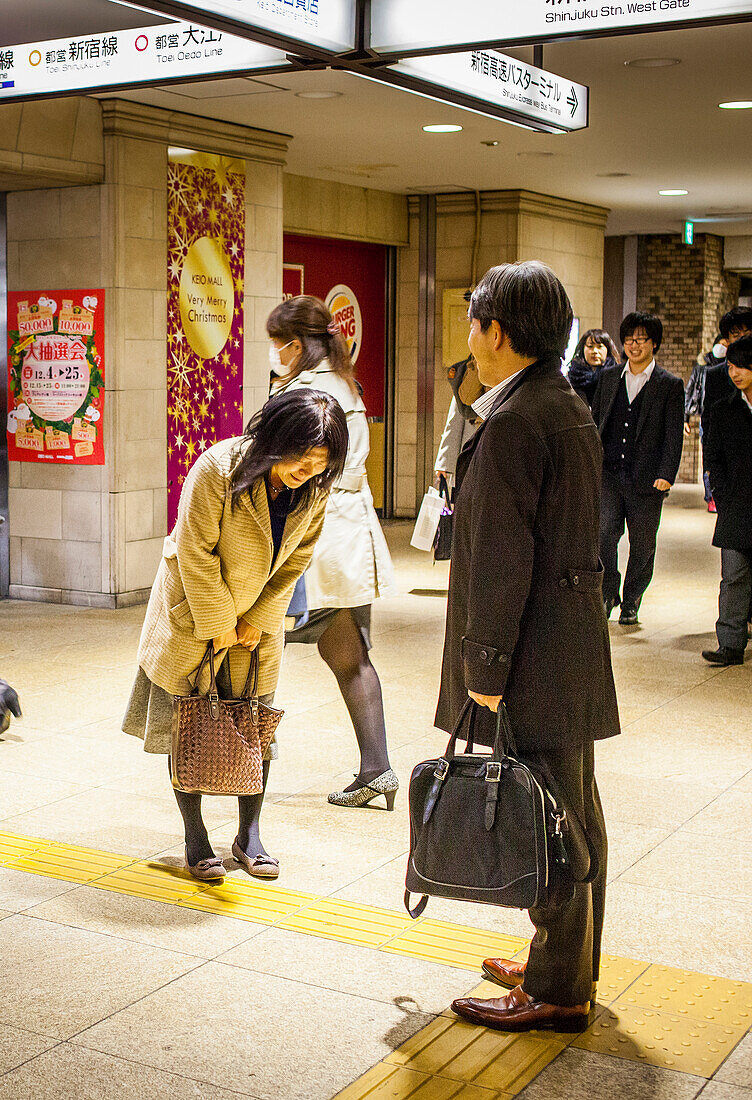 Friends saying goodbye, at Shinjuku Railway station, Tokyo, Japan.