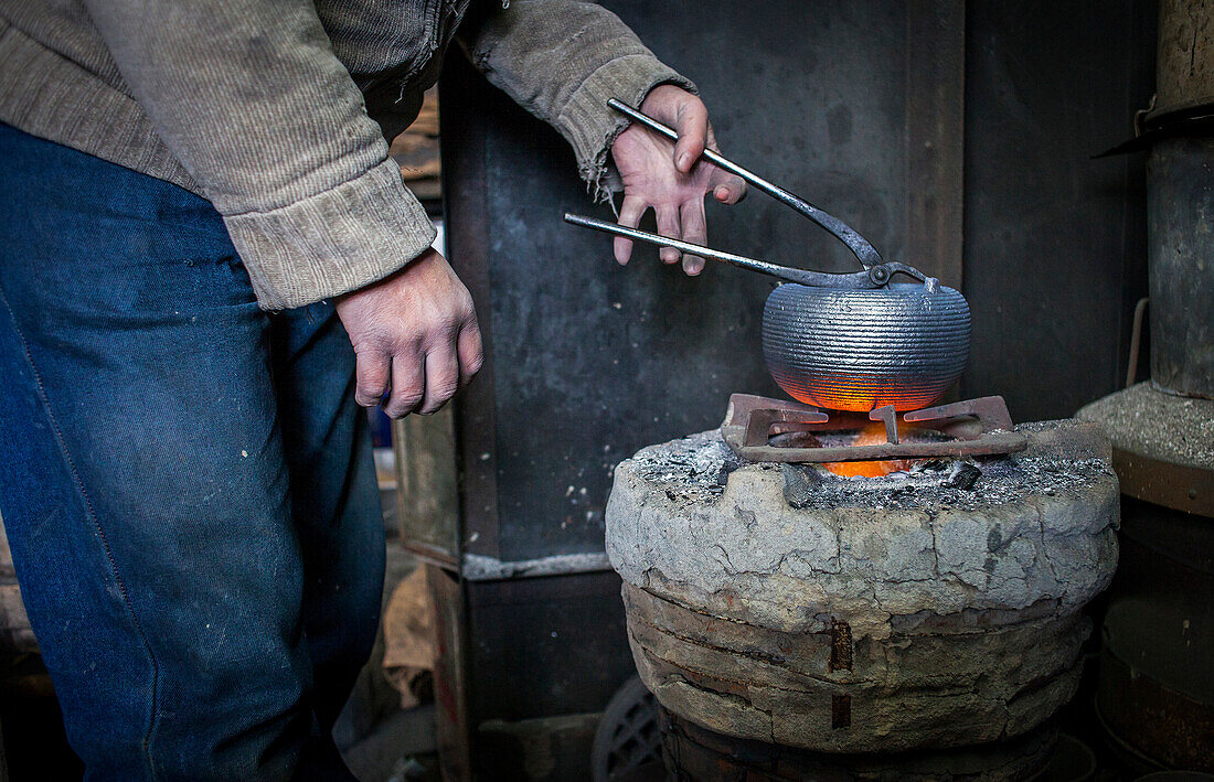Takahiro Koizumi is putting the finishing touches at iron teapot or tetsubin, nanbu tekki,Workshop of Koizumi family,craftsmen since 1659, Morioka, Iwate Prefecture, Japan