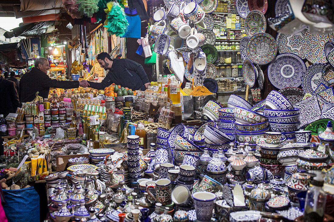 Friends greeting each other, market, ceramic and pottery shop, medina, Fez. Morocco