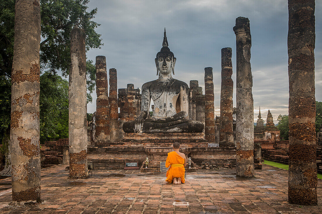 Monk praying, in Wat Mahathat, Sukhothai Historical Park, Sukhothai, Thailand