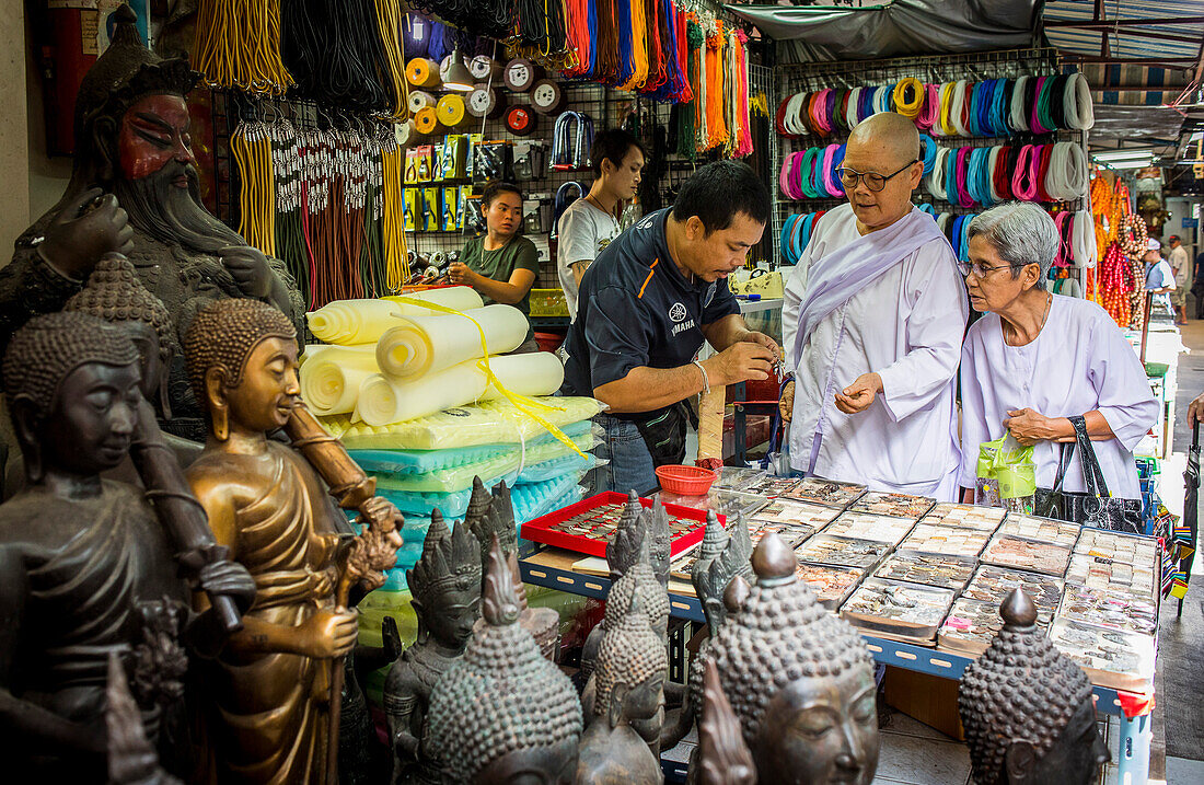 Buddhistische Nonnen suchen buddhistische Amulette, auf dem Amulettmarkt, Bangkok, Thailand.